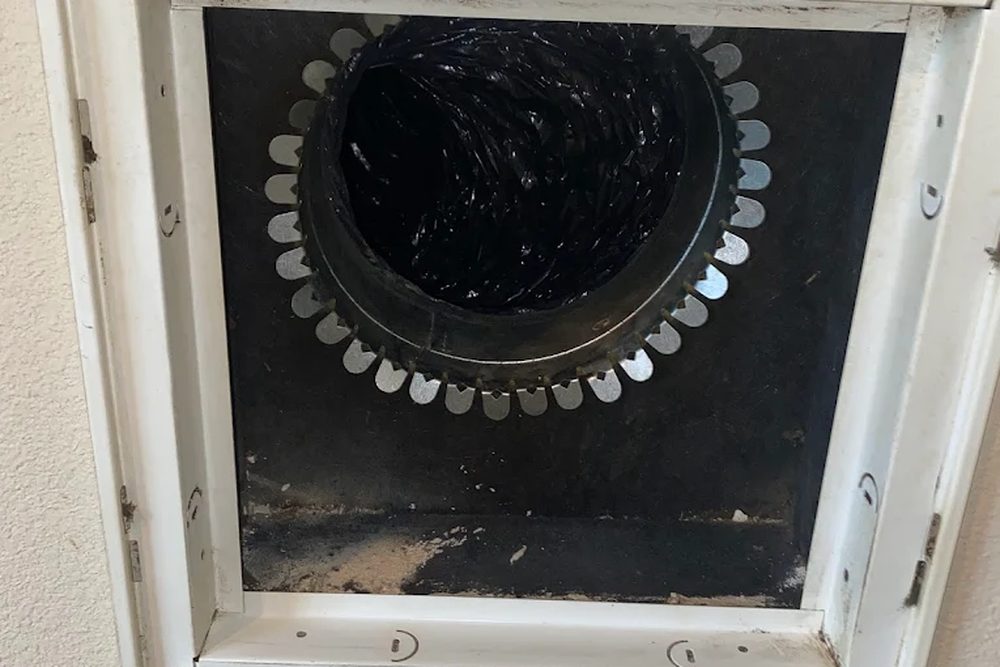 A wall register with its grille removed, showing the round duct opening behind it