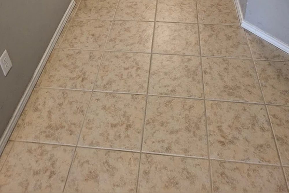 A beige ceramic tile hallway floor with clean grout lines